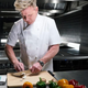 Gordon Ramsay chops vegetables on a cutting board